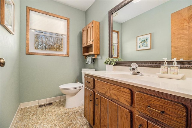 bathroom with visible vents, baseboards, toilet, tile patterned flooring, and vanity