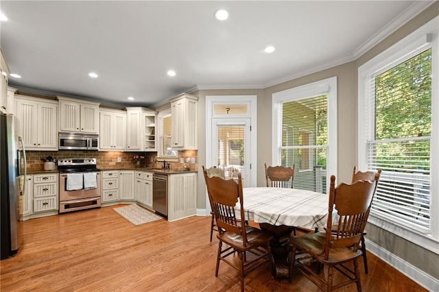 kitchen featuring plenty of natural light, tasteful backsplash, appliances with stainless steel finishes, and crown molding