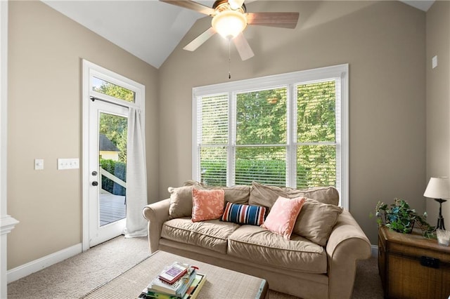 living area featuring ceiling fan, vaulted ceiling, baseboards, and light carpet