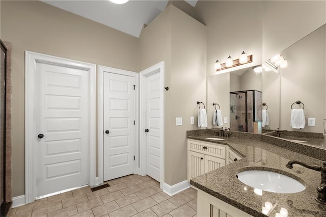bathroom with tile patterned flooring, a sink, a shower stall, and double vanity