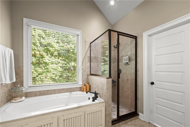 bathroom featuring a shower stall, a bath, and plenty of natural light