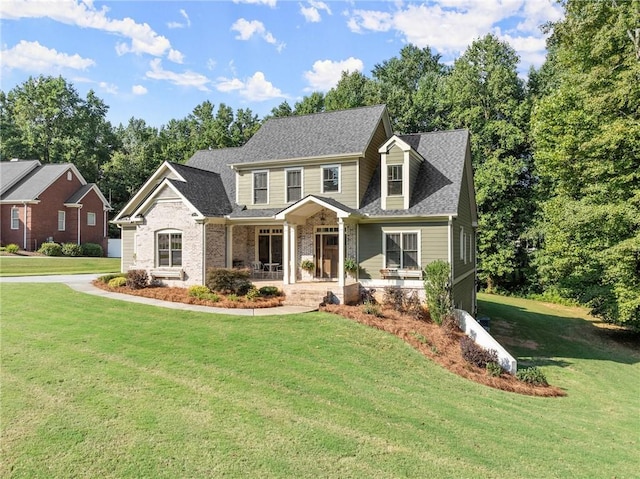 view of front of property with a porch, a shingled roof, and a front yard
