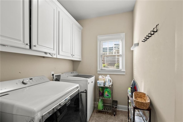 laundry area featuring baseboards, washer and clothes dryer, and cabinet space
