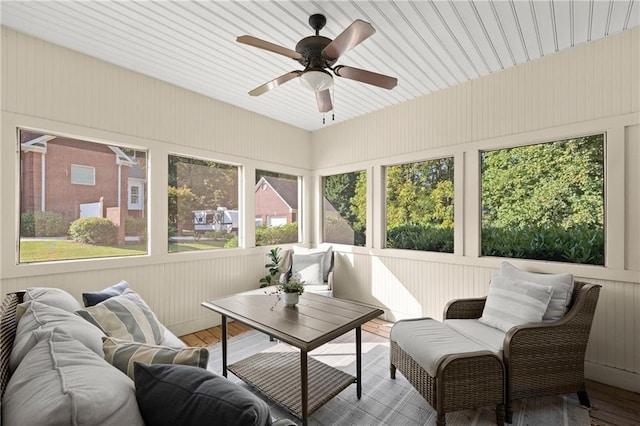 sunroom featuring wood finished floors, ceiling fan, and an outdoor living space