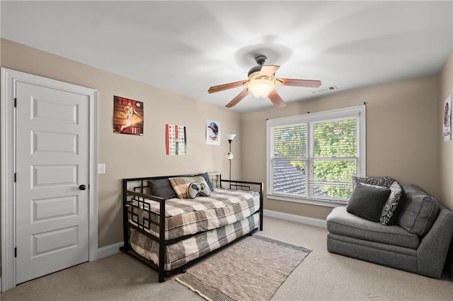carpeted bedroom with visible vents, a ceiling fan, and baseboards