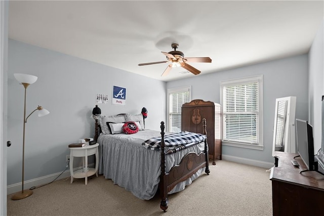 bedroom featuring light carpet, a ceiling fan, and baseboards