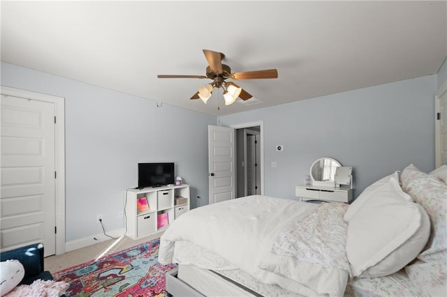 carpeted bedroom with a ceiling fan and baseboards