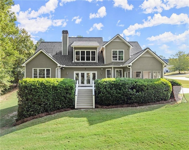 rear view of house featuring a lawn, a chimney, stairway, and roof with shingles
