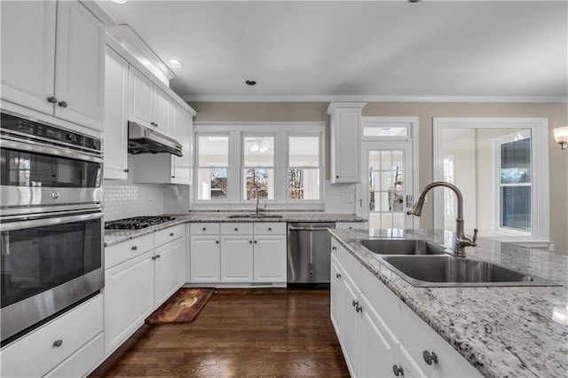 kitchen with white cabinets, appliances with stainless steel finishes, backsplash, and sink