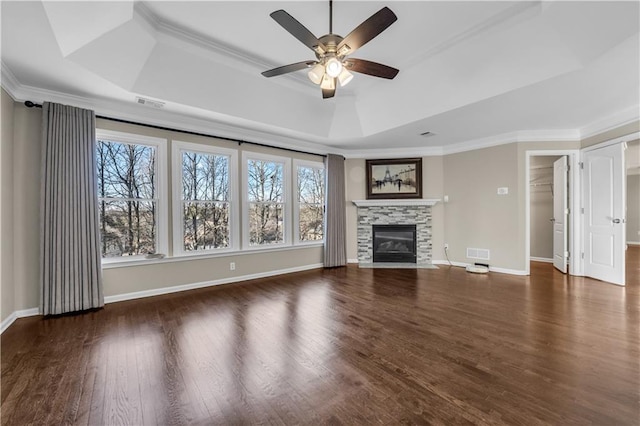 unfurnished living room with a fireplace, dark wood-type flooring, ceiling fan, and a tray ceiling