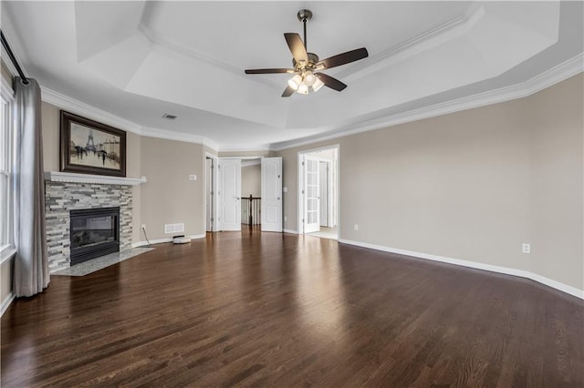 unfurnished living room featuring crown molding, dark hardwood / wood-style floors, a raised ceiling, and a fireplace