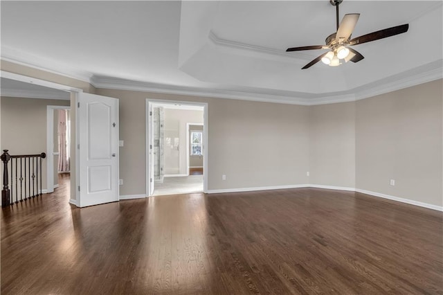 unfurnished room with a tray ceiling, crown molding, and dark hardwood / wood-style floors