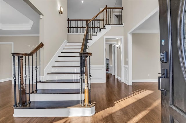 foyer entrance with dark hardwood / wood-style flooring and crown molding