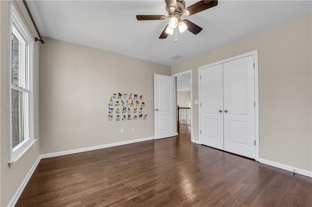 unfurnished bedroom with ceiling fan, a closet, and dark hardwood / wood-style floors