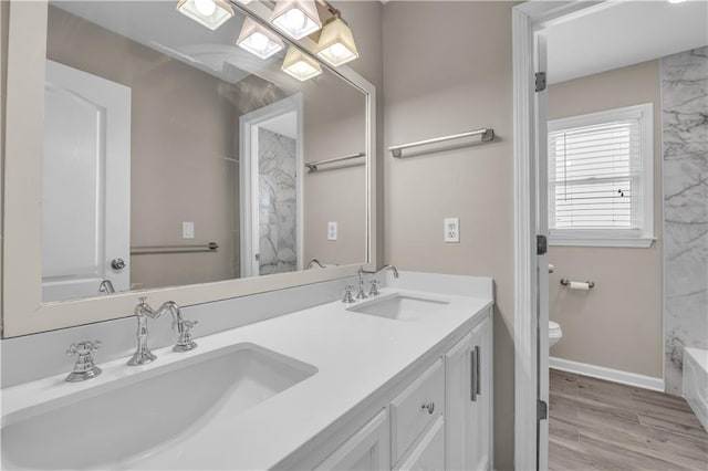 bathroom with toilet, vanity, and hardwood / wood-style floors