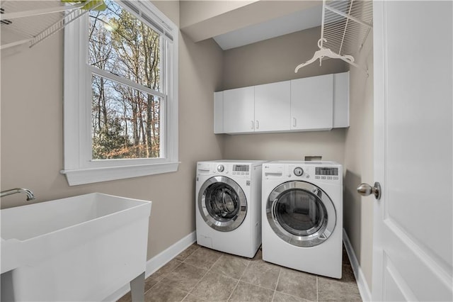 clothes washing area with cabinets, separate washer and dryer, and sink