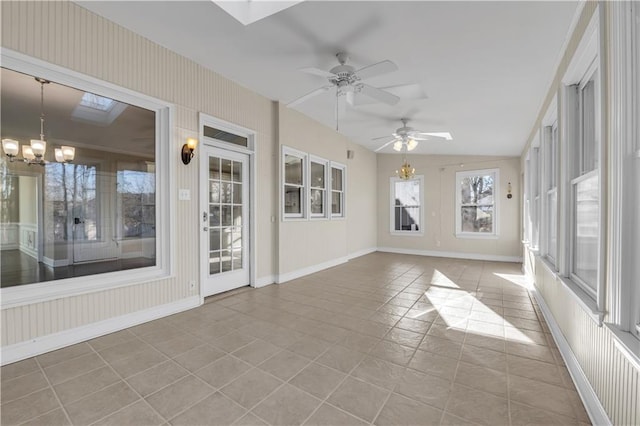 unfurnished sunroom featuring lofted ceiling with skylight and ceiling fan with notable chandelier