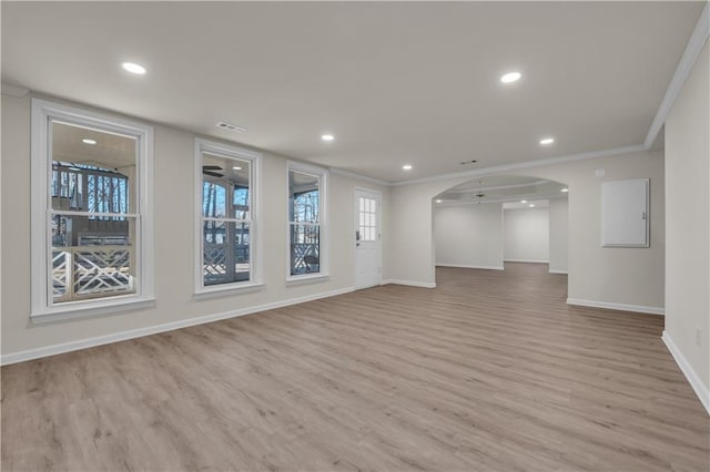 empty room with ornamental molding and light hardwood / wood-style flooring