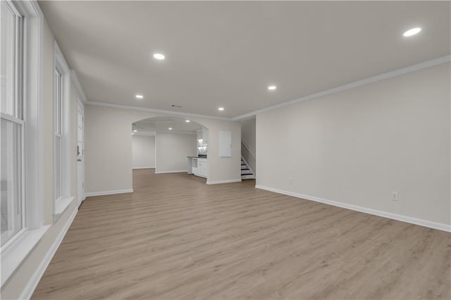 unfurnished living room with light wood-type flooring and crown molding