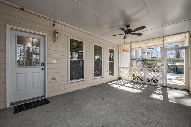 unfurnished sunroom featuring ceiling fan