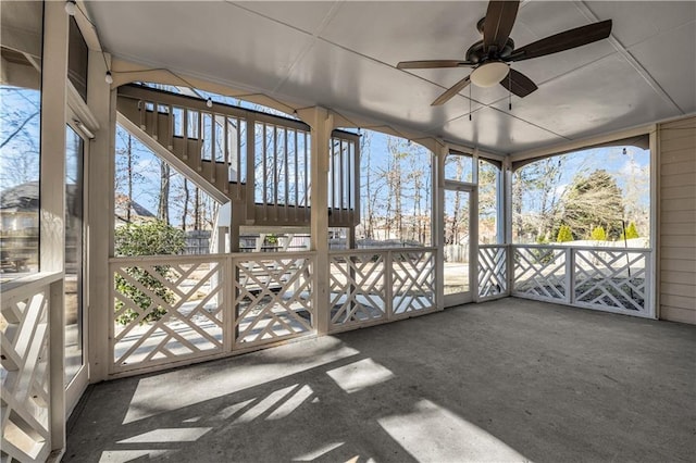 unfurnished sunroom with ceiling fan