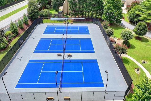 view of tennis court featuring a yard and basketball hoop