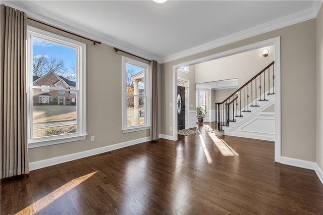 foyer featuring ornamental molding, a wealth of natural light, and dark wood-type flooring