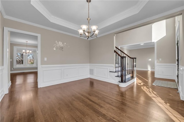 spare room with a chandelier, a tray ceiling, and crown molding