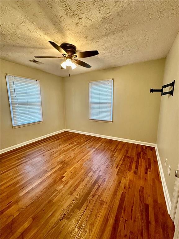 spare room featuring ceiling fan, a textured ceiling, and hardwood / wood-style flooring