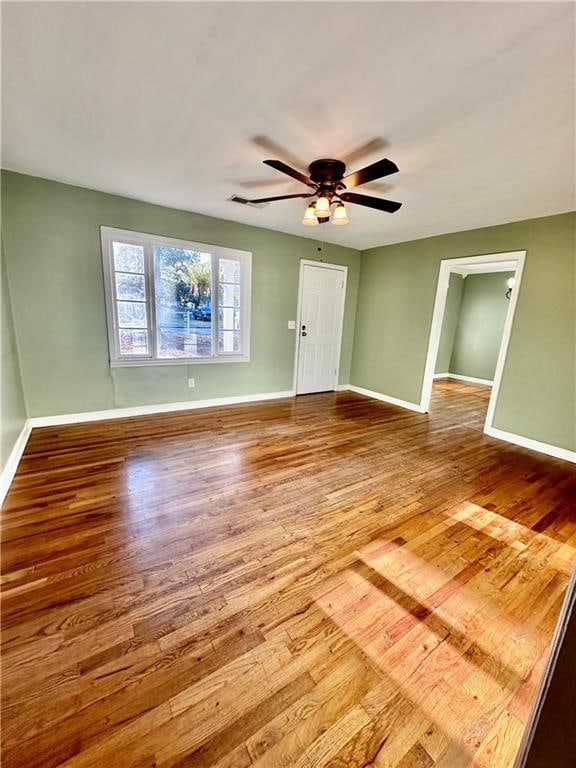 unfurnished room with ceiling fan and wood-type flooring