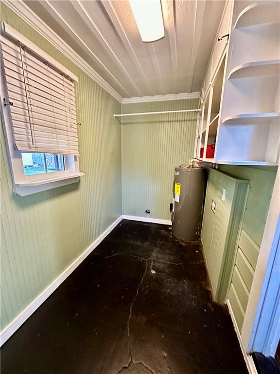 laundry room with ornamental molding and water heater