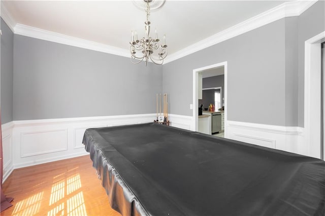 game room featuring pool table, crown molding, a notable chandelier, and wood finished floors