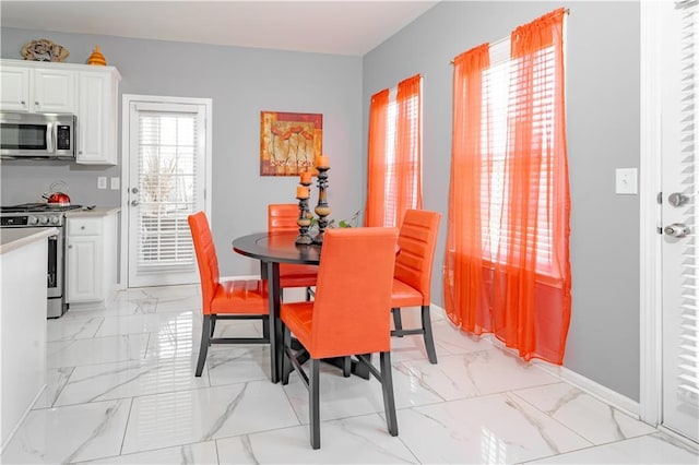 dining space featuring marble finish floor and baseboards