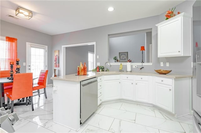 kitchen with a sink, marble finish floor, light countertops, and dishwasher