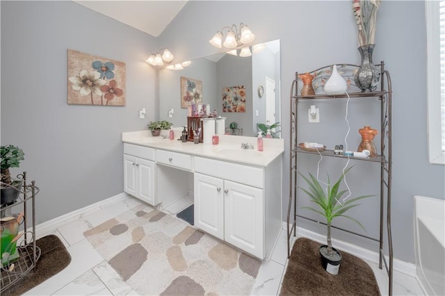 bathroom with baseboards, marble finish floor, a bathtub, vaulted ceiling, and vanity