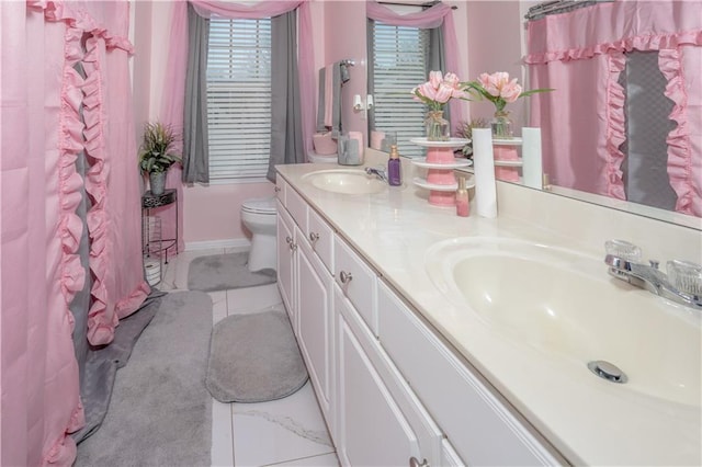 bathroom with double vanity, a shower with shower curtain, a sink, and toilet