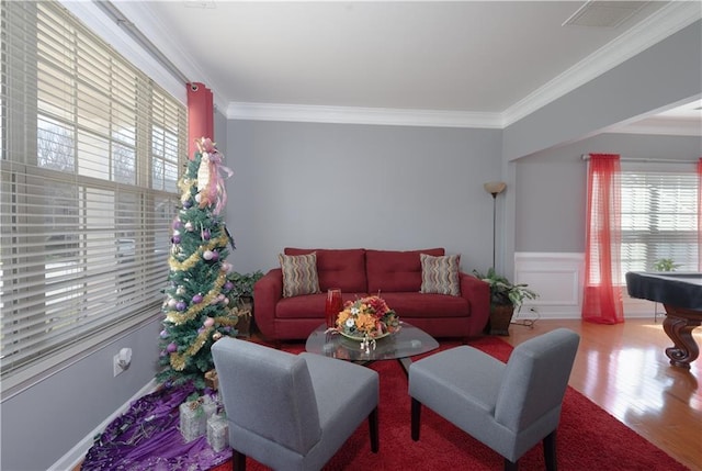 living area with ornamental molding, wood finished floors, and visible vents