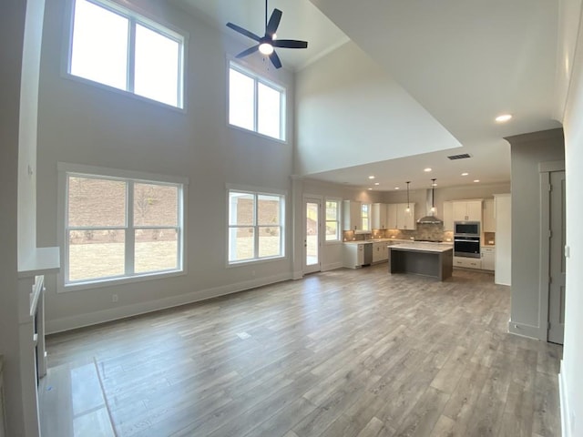 unfurnished living room featuring ceiling fan, recessed lighting, visible vents, baseboards, and light wood-style floors