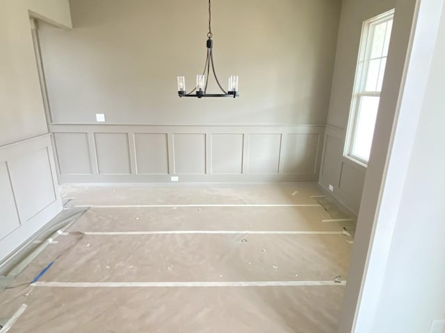 unfurnished dining area featuring a notable chandelier