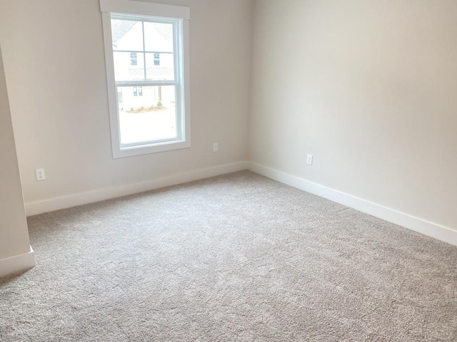 carpeted spare room with baseboards