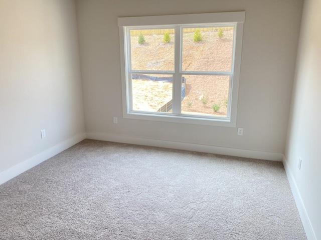 carpeted empty room with baseboards