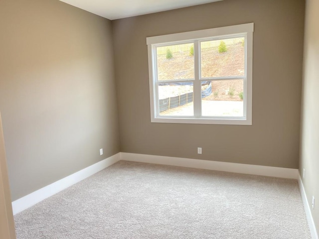 carpeted spare room featuring baseboards