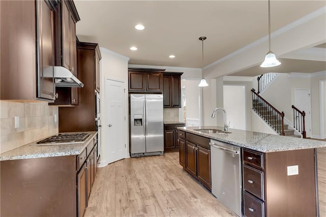 kitchen with light wood-style flooring, a sink, ornamental molding, dark brown cabinetry, and stainless steel appliances