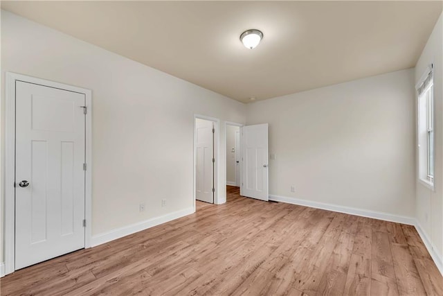 unfurnished room featuring baseboards and light wood-style floors