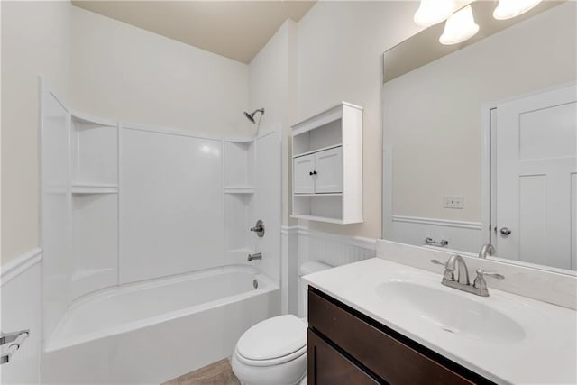 full bath featuring tub / shower combination, a wainscoted wall, toilet, and vanity