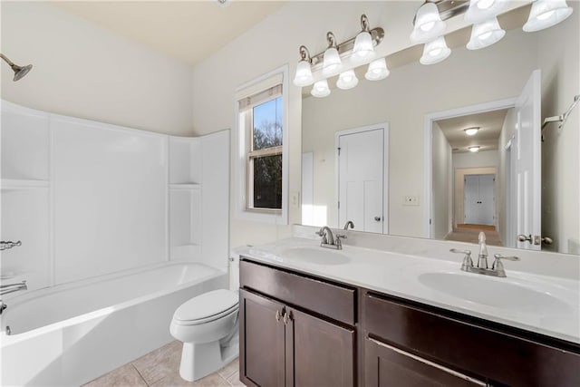 bathroom with a sink, toilet, double vanity, and tile patterned floors