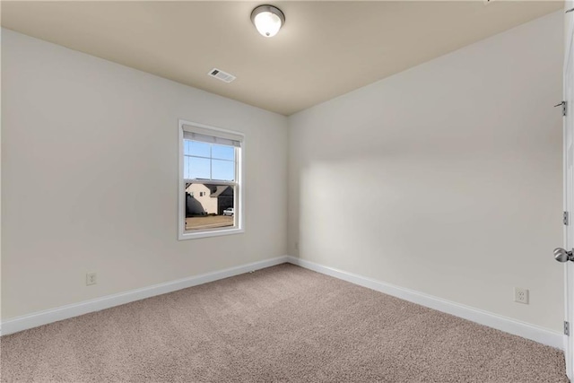 unfurnished room with visible vents, light carpet, and baseboards