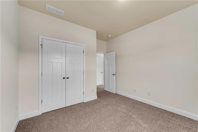 unfurnished bedroom featuring a closet, visible vents, baseboards, and carpet