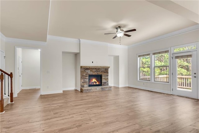 unfurnished living room featuring stairs, a stone fireplace, light wood-style flooring, and baseboards