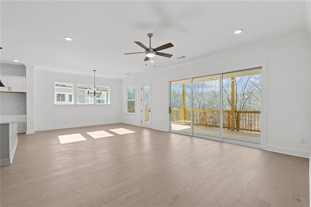 unfurnished living room featuring crown molding, ceiling fan with notable chandelier, and light hardwood / wood-style floors